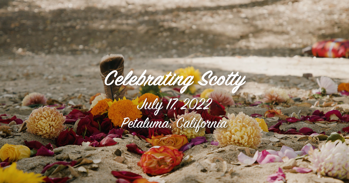 A freeze frame from video title screen, which reads, in white script: Celebrating Scotty, July 17, 2022, Petaluma, California. The text is overlaid on a low angle shot of a flower mandala laid out on sandy soil in an oak grove, at its center the tail of a red-shouldered hawk stands upright.